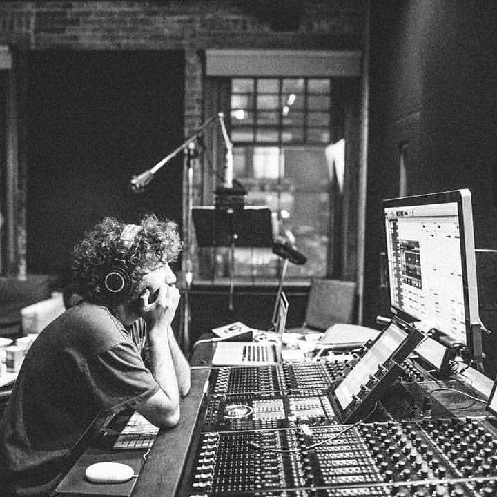 Artistic black-and-white shot of Benny Blanco at a mixing console
